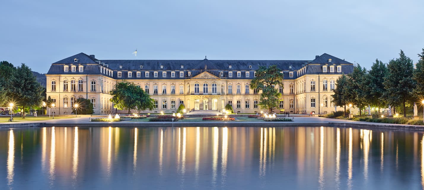 Das schön beleuchtete neue Schloss spiegelt sich im Wasser